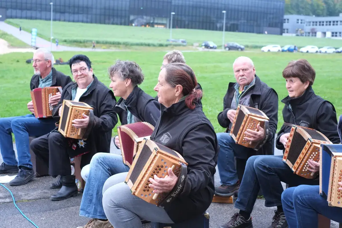 Accordion players sitting in front of the hall, on race day